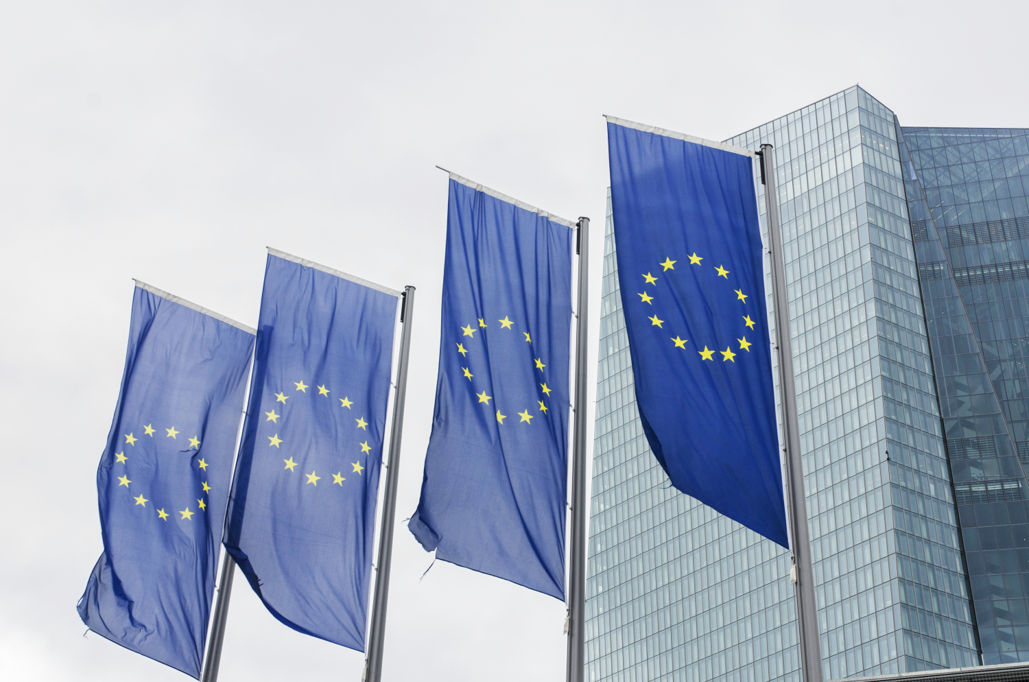 Four EU flags flying in front of a building