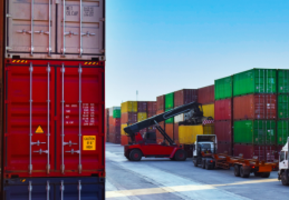 A truck stands parked adjacent to a container truck, illustrating a scene of logistics and transport.